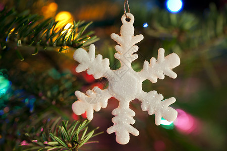 白色雪花闪烁着圣诞装饰品挂在圣诞树图片