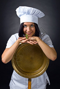 穿着大铜锅的厨师制服的年轻女子图片