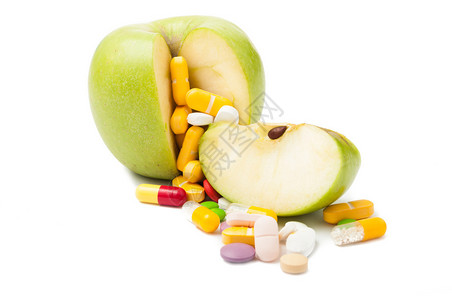 彩色药丸和绿苹果饮食概念孤图片