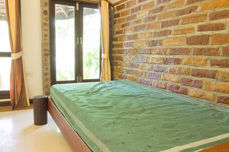 在砖墙背景旁边的一张单人床图片