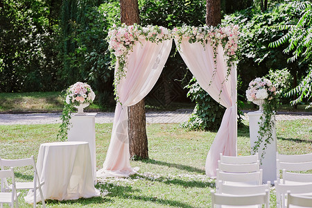 基建狂魔婚礼仪式的拱门在树前装饰着布背景