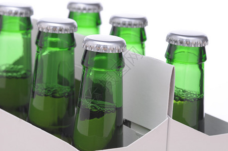 六包绿色啤酒瓶子的关闭由纸板运货员以图片