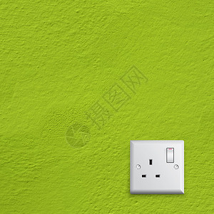 绿色墙上的简单白色英国电插座图片