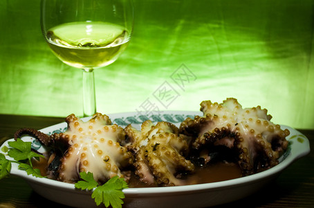食品和饮料意大利食谱带章鱼的盘子和带白葡萄酒的玻璃杯图片