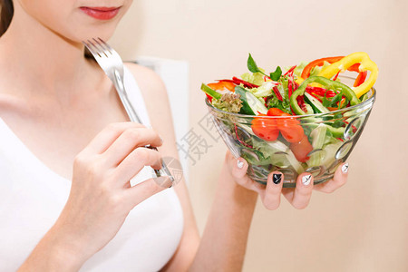 妇女在玻璃碗里拥有新鲜蔬菜沙拉的妇女图片