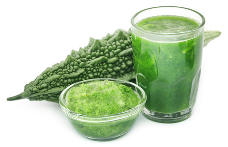 白色背景玻璃中绿色苦瓜的草本汁图片