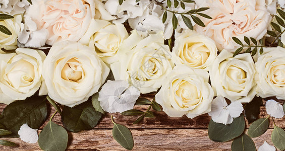 花朵在木制背景上安排美丽的白玫瑰图片
