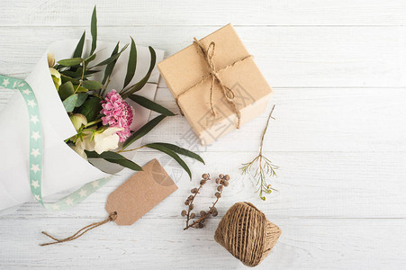 带标签的礼品盒木质背景一束鲜花图片