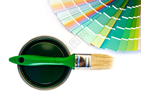 不同深浅的绿色样品和带刷子的绿色油漆罐头专注于罐头在白图片
