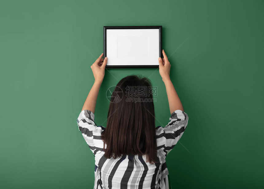 彩色墙上挂着相框的女人图片