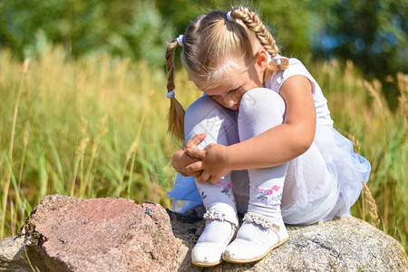 小女孩在街上迷路坐在石头上哭泣在阳图片