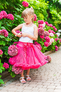 美丽的小女孩穿着明亮的粉红裙和白色上衣图片