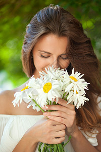 年轻女人闻着一束花的香味图片