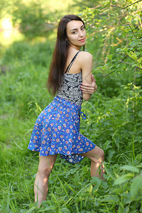 在绿色夏日草原背景的年轻女孩图片
