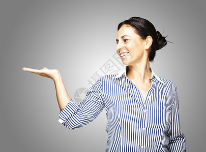 一个中年妇女在灰色上举手的肖像图片