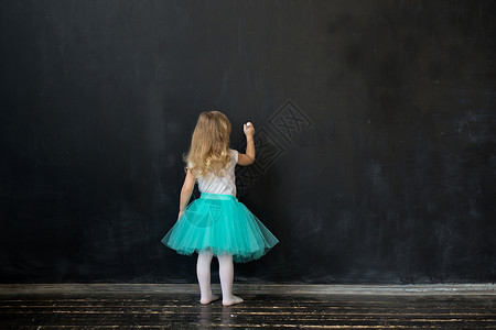 女孩用粉笔在黑板上写字图片
