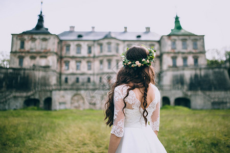 美丽的时尚新娘在古老城堡的草坪图片
