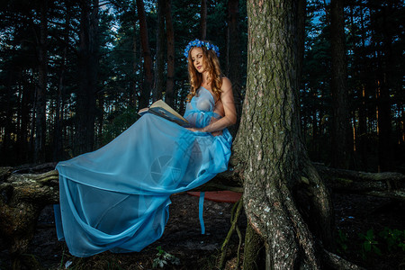 穿着蓝裙子的孕妇的艺术肖像出现在图片