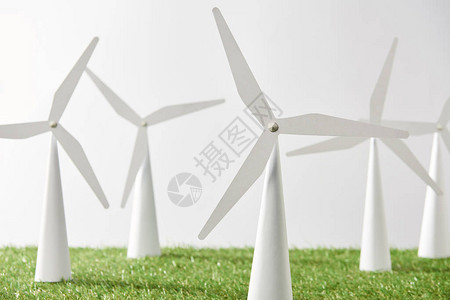 绿草和白色背景上的风车模型图片