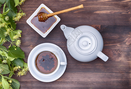 凉茶和壶放在木桌上面有椴树的枝图片