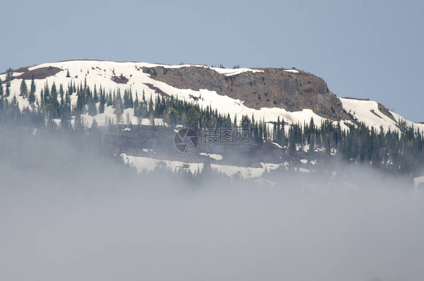 站在云层之上的雪山峰图片