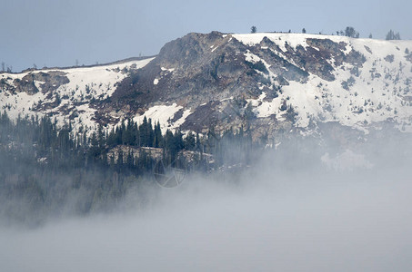 站在云层之上的雪山峰图片