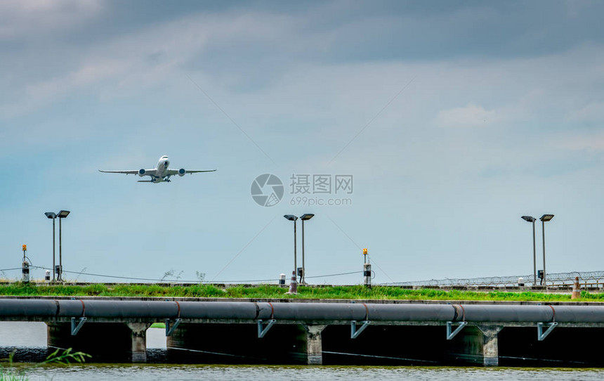 客机在美丽的蓝天和云彩的机场起飞离开飞行开启海外之旅放假时间机场的围栏和太阳能电池板图片