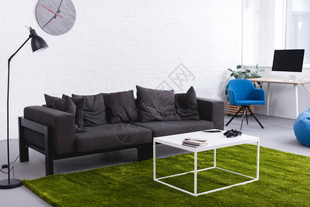 灰色沙发和绿色地毯客厅里有桌子背景图片