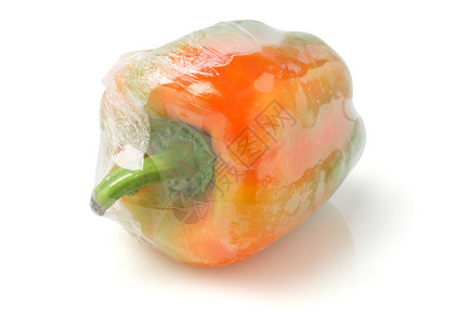 新鲜胡椒包裹在白色背景上的玻璃纸薄膜图片