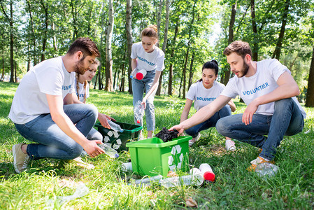 青年志愿者与绿色回收箱图片