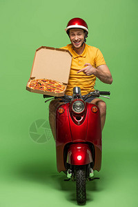 穿着黄色制服的骑摩托车手用指对着绿色比萨图片