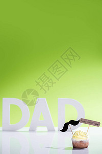 带着小胡子的纸杯蛋糕和快乐的父亲节在父亲面前用绿色白字写图片