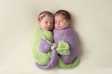 新生女婴在浅绿色和熏衣草包扎材料中相聚在一起图片