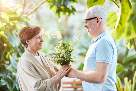 快乐的老太婆从丈夫手里拿一堆白花亲吻他们的图片