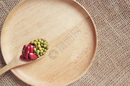 红豆与青豆或绿豆在木盘上的木勺图片