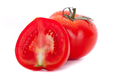 一个完整的番茄和一个减半的番茄的特写图片