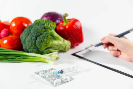 蔬菜饮食营养或药物概念女手写饮食计划成熟蔬菜组合物药物和白色背图片