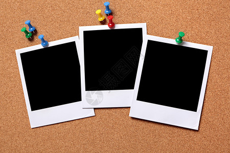 三个空白的照片指纹被钉在软木布告板图片