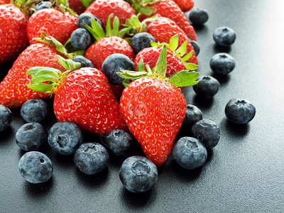 黑色背景的新鲜草莓和蓝莓组图片
