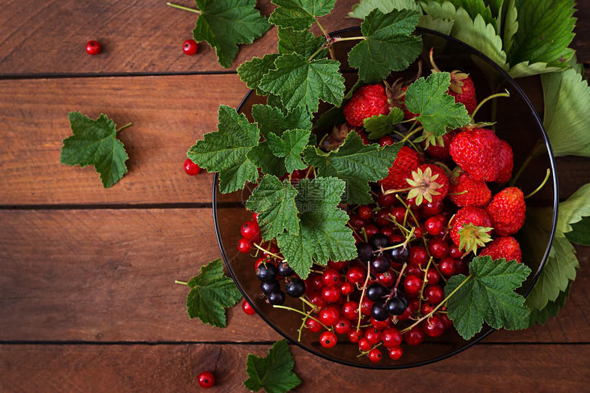 在黑木背景上配有新鲜浆果草莓和草莓图片