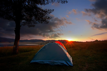 高山湖附近的娱乐区和有帐篷的营地日落时间和太阳升图片