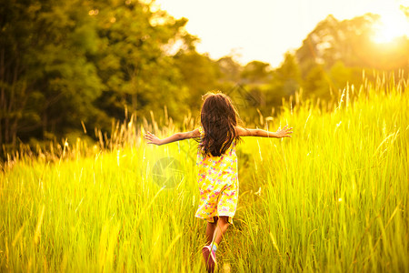 小女孩在的草地上奔跑图片