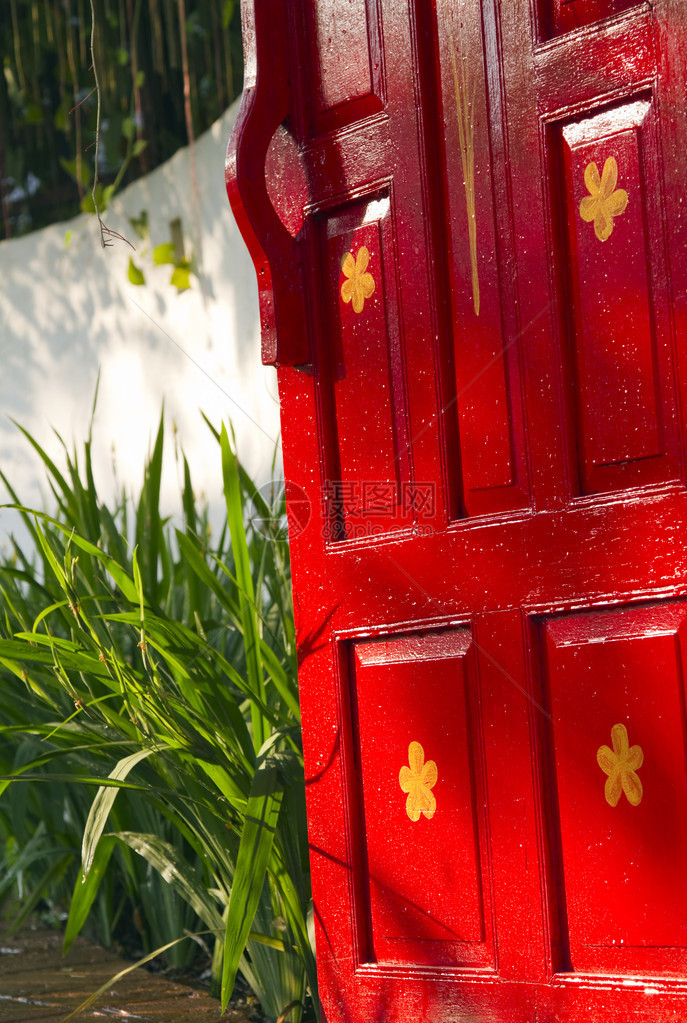 明亮的红漆色木制门通向一片平图片