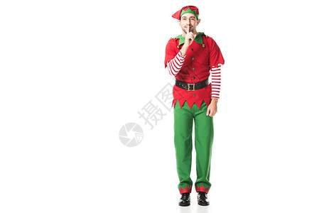 穿着圣诞精灵服装微笑的男人展示了安静的沉默标志看着在白色上图片