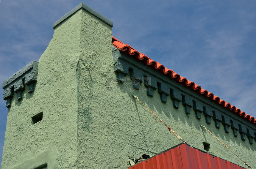 与红色屋顶和在绿色的石膏上笼罩着蓝色天空的蓝天图片