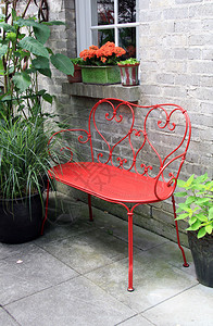 花园露台外面的红色锻铁长凳图片