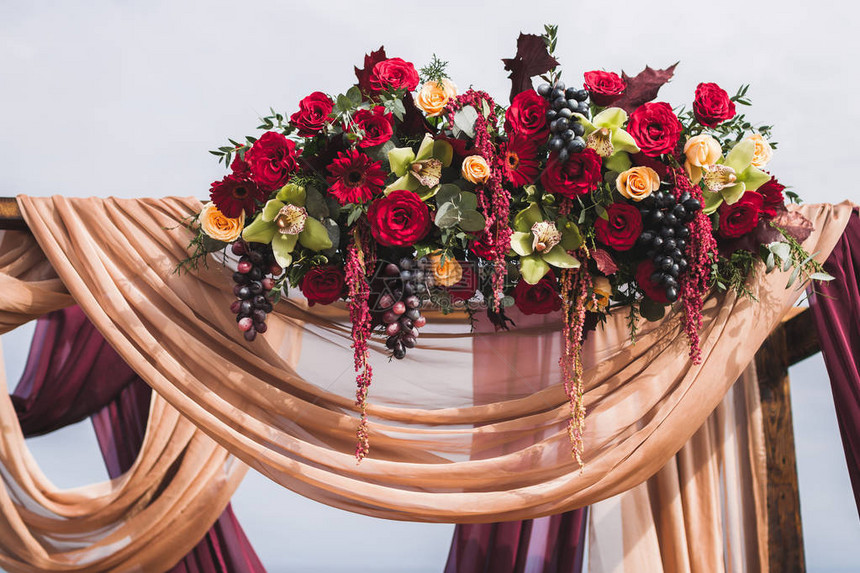 婚礼仪式用红玫瑰黄兰花葡萄紫和蜜菜图片
