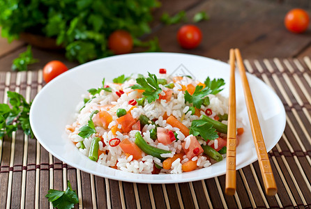 开胃健康米饭白盘蔬菜放在木制背景上有图片