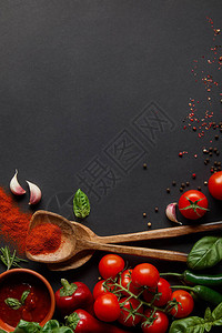 红樱桃番茄辣椒番茄酱蒜瓣和新鲜香草的顶视图靠近勺子图片