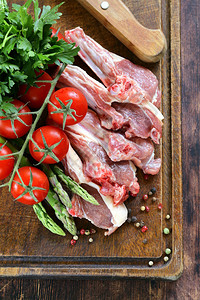 生肉羊排和木板上的蔬菜图片